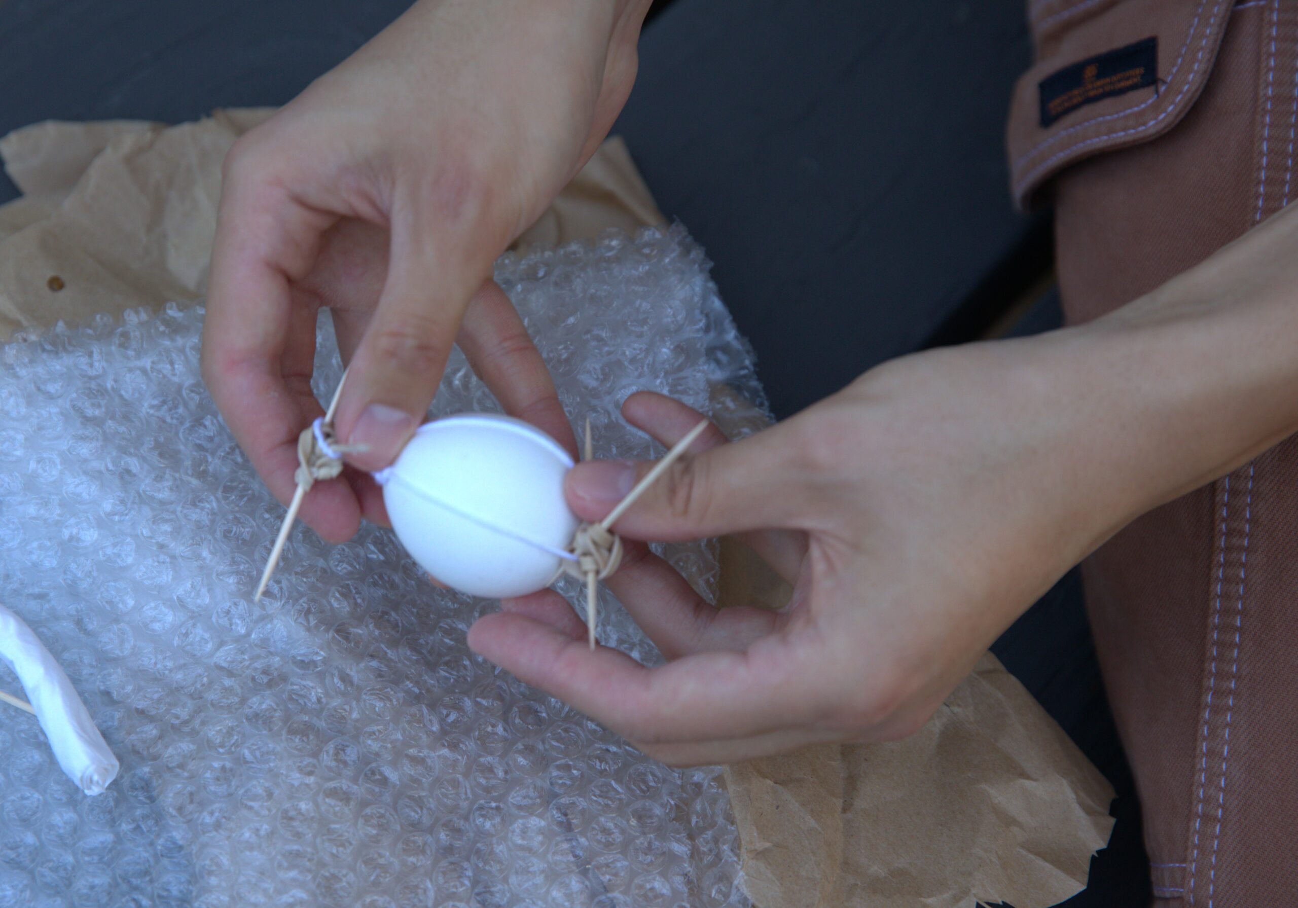 Detail of a student working on a package to protect an egg