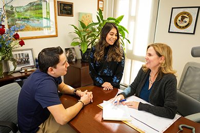 Lisa Sperow working with student team leaders in her office.