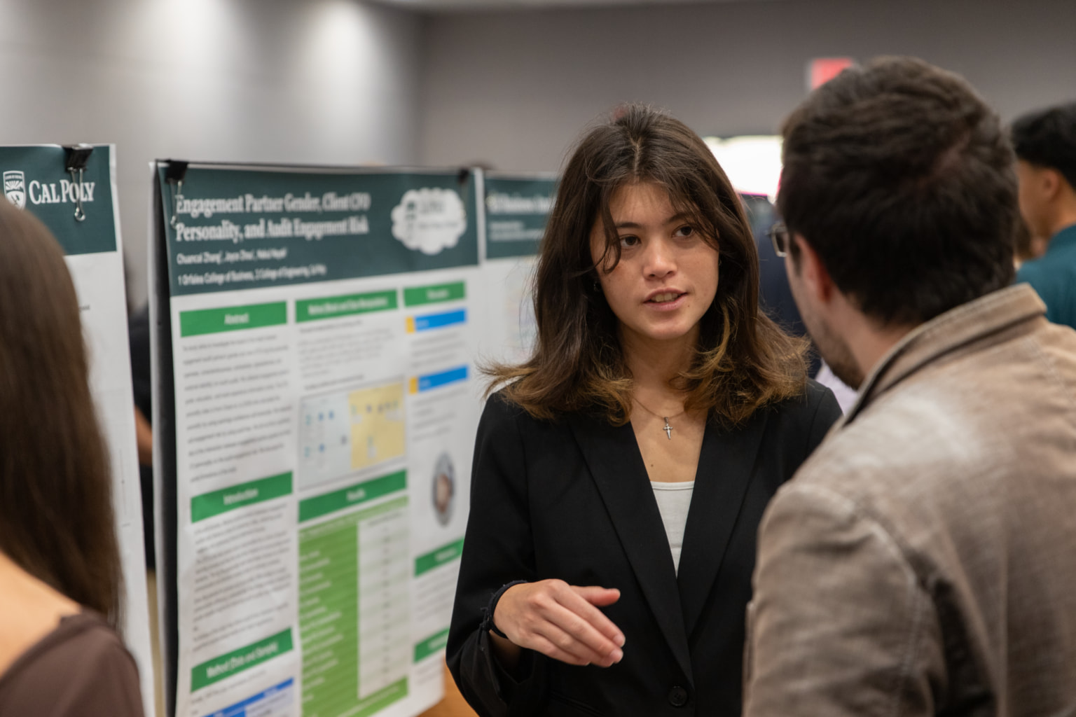 A student discusses her research at a symposium