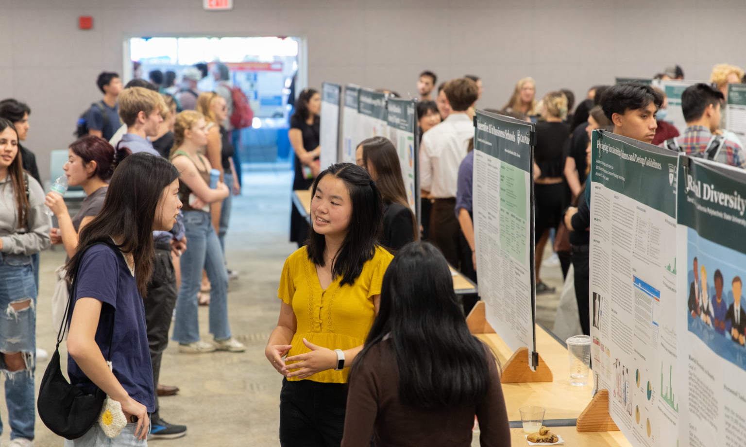 Students and faculty members talk during a symposium filled with posters