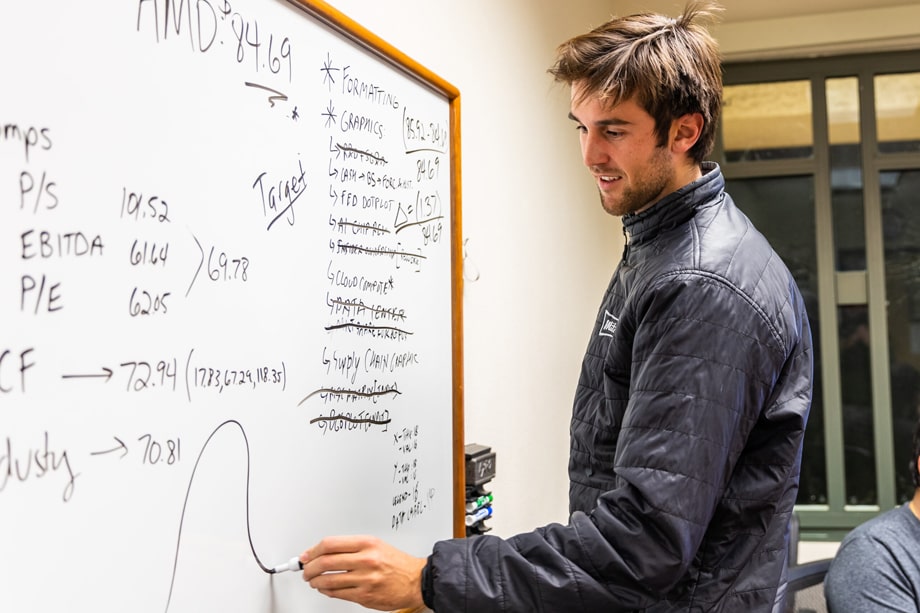 Benjamin Roe, student, writing on a whiteboard.