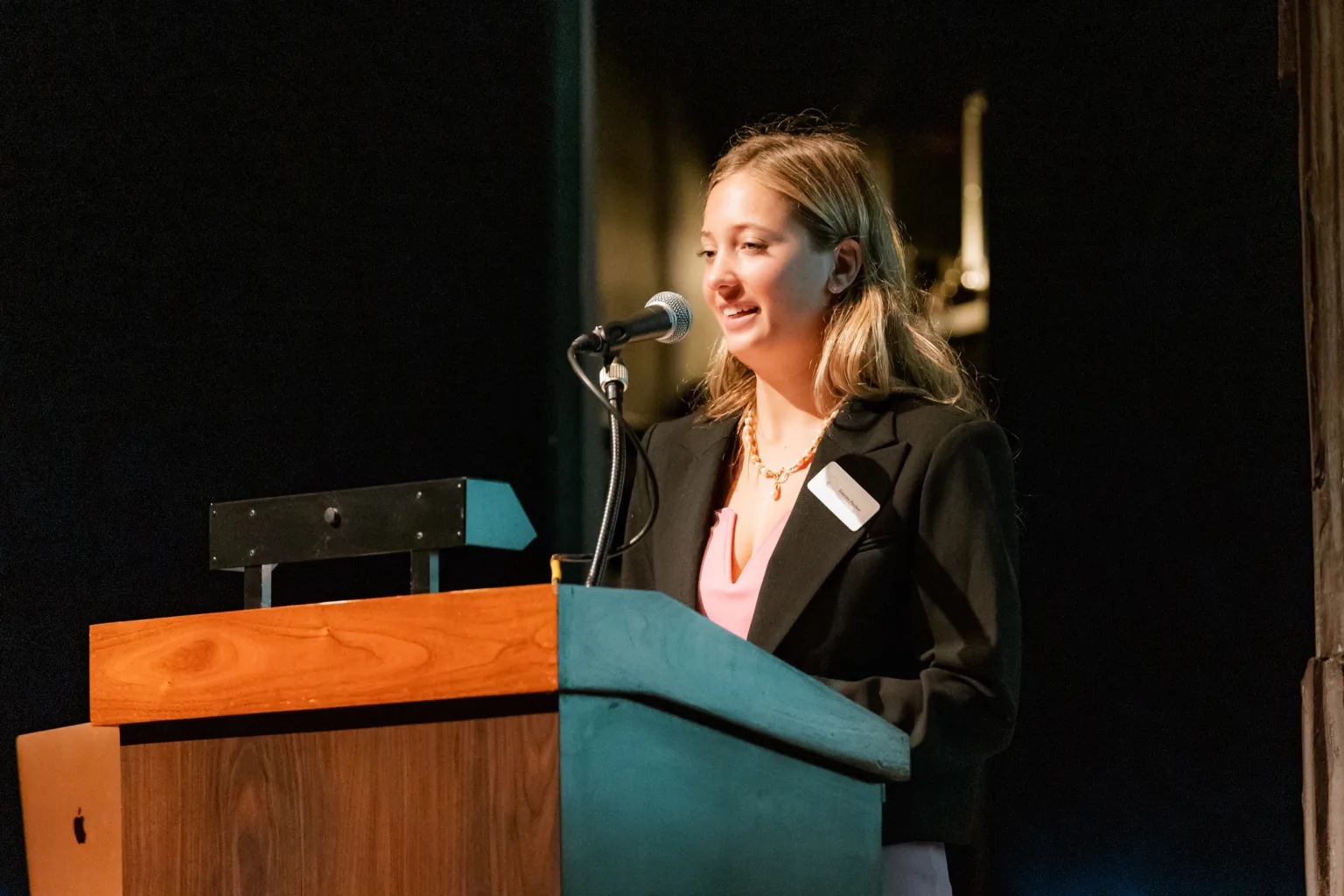 A speaker at a podium addresses the audience