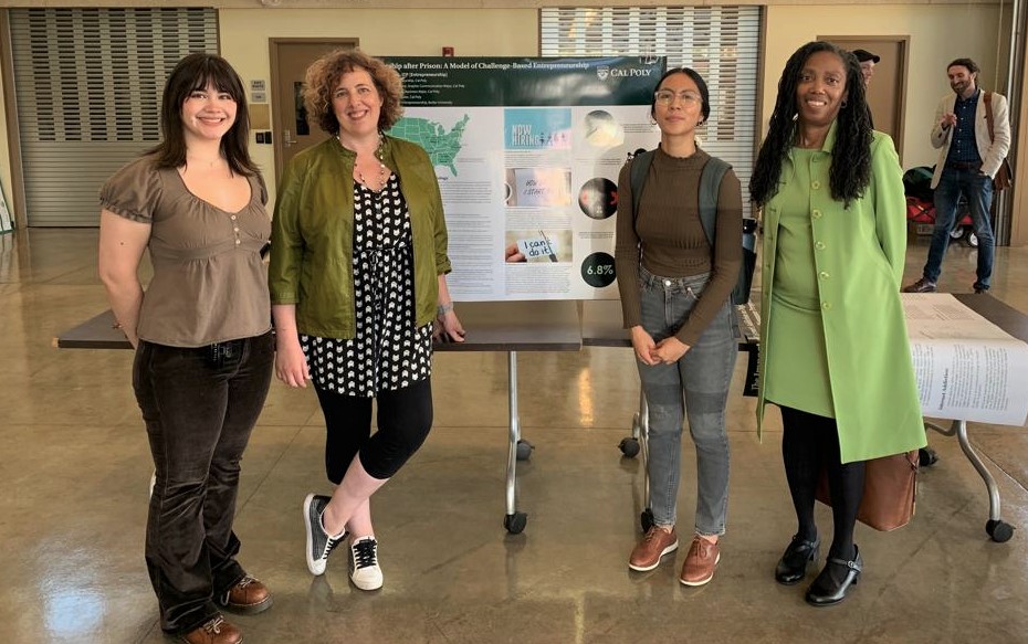 Three students at SURP posing in front of a presentation with Provost Cynthia Jackson-Elmoore.