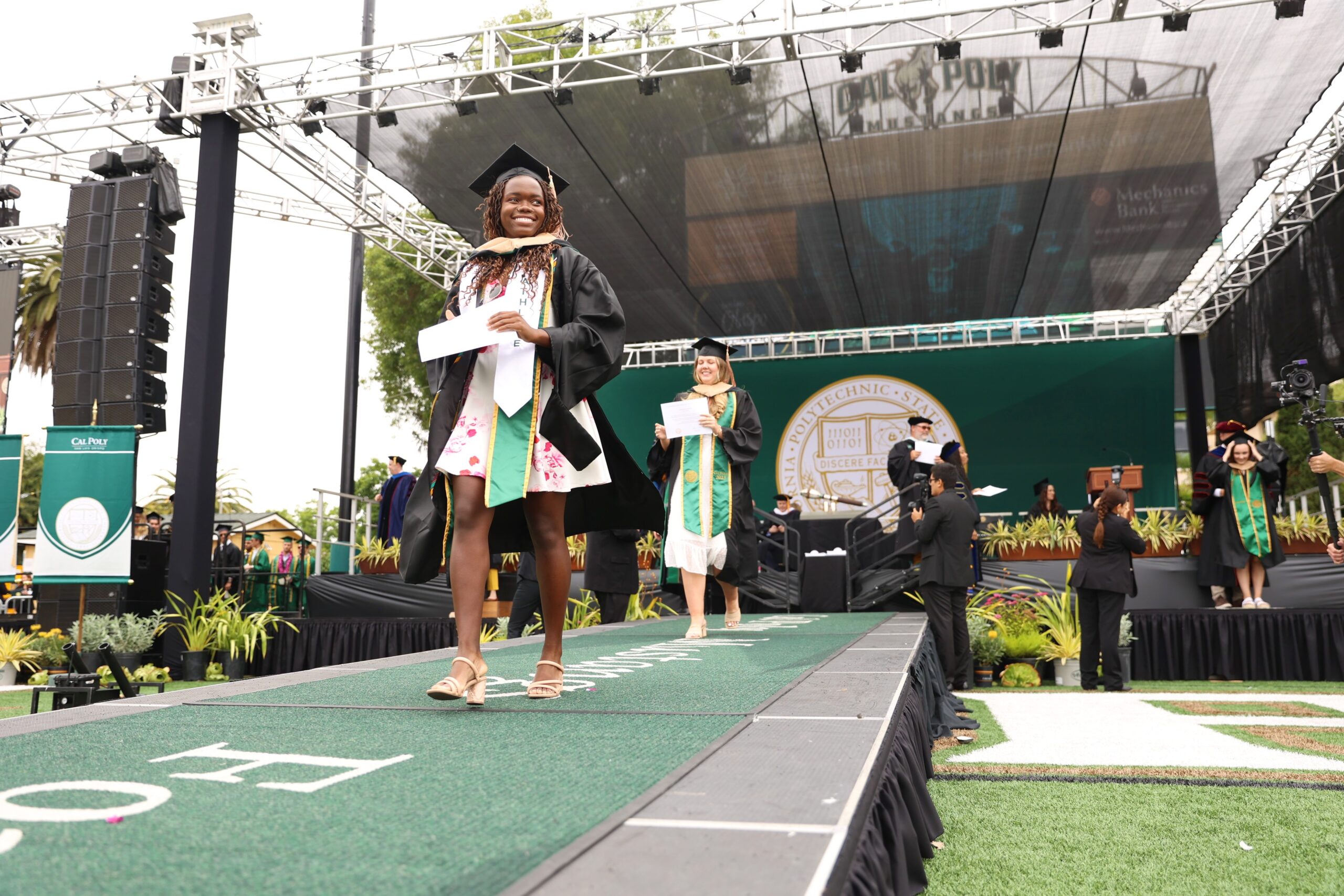 Kim Bhunu, in cap and gown and diploma in her hand, at commencement