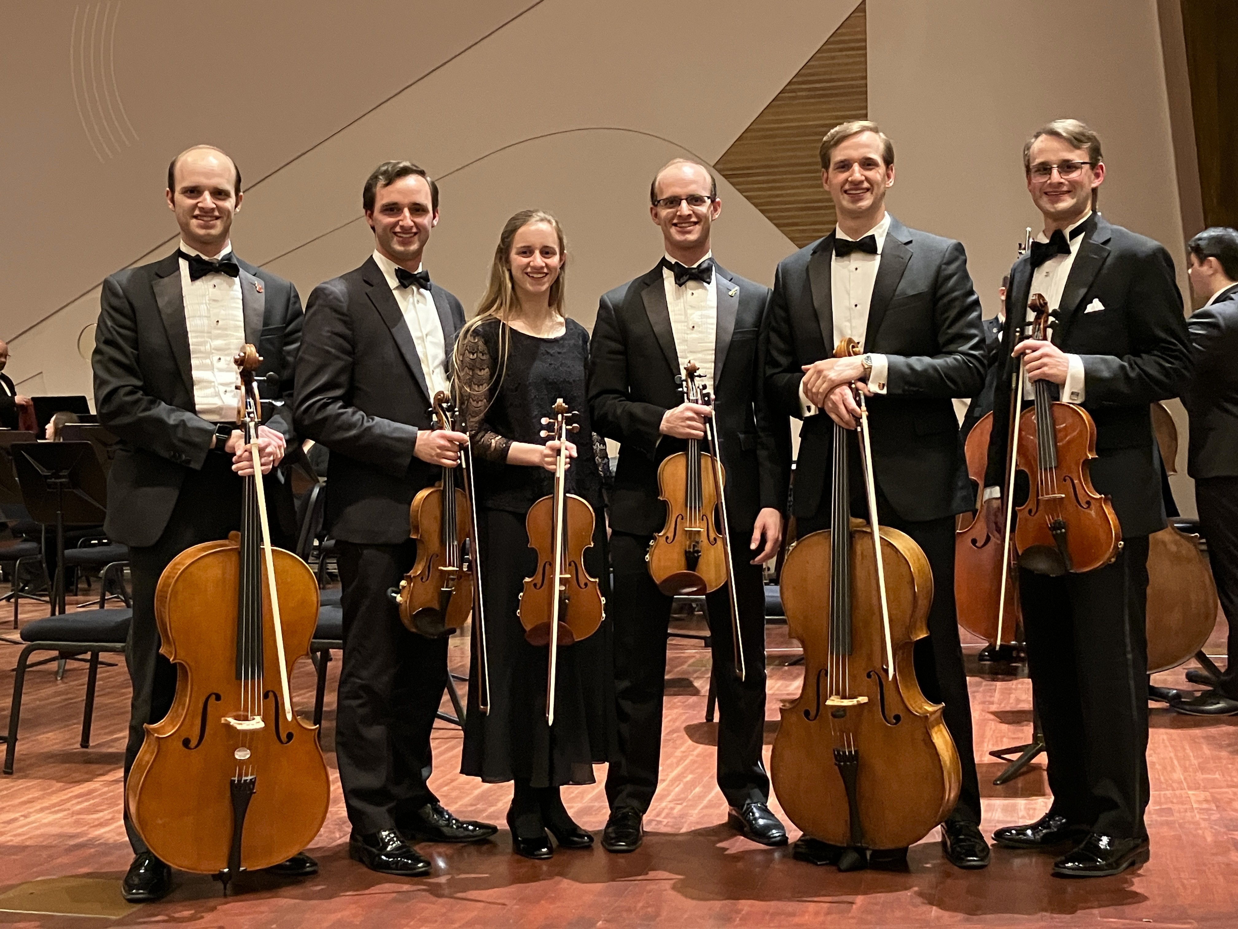 Elijah Shanks and his siblings, in symphony attire, with stringed instruments