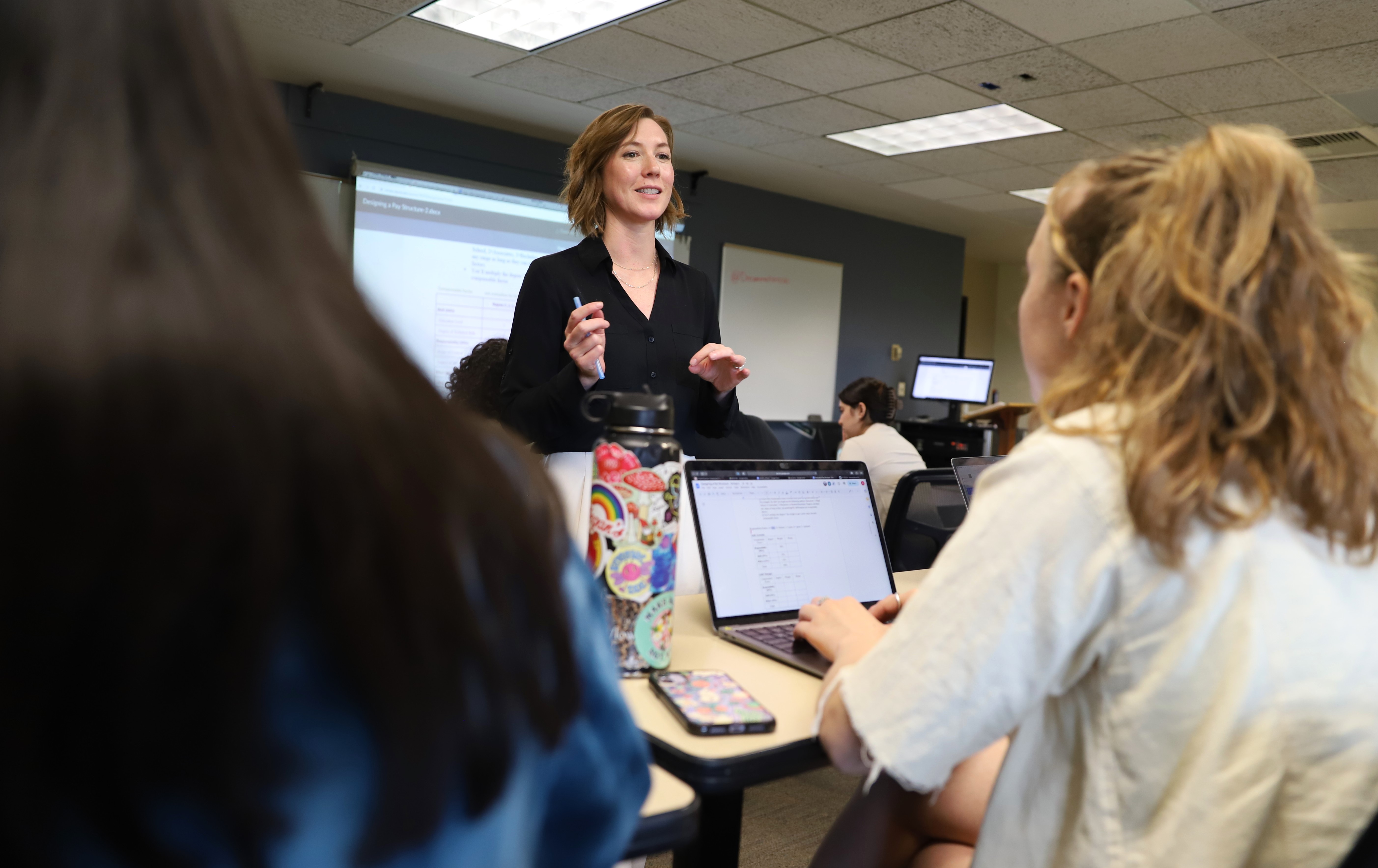 A management professor talks to students in class.