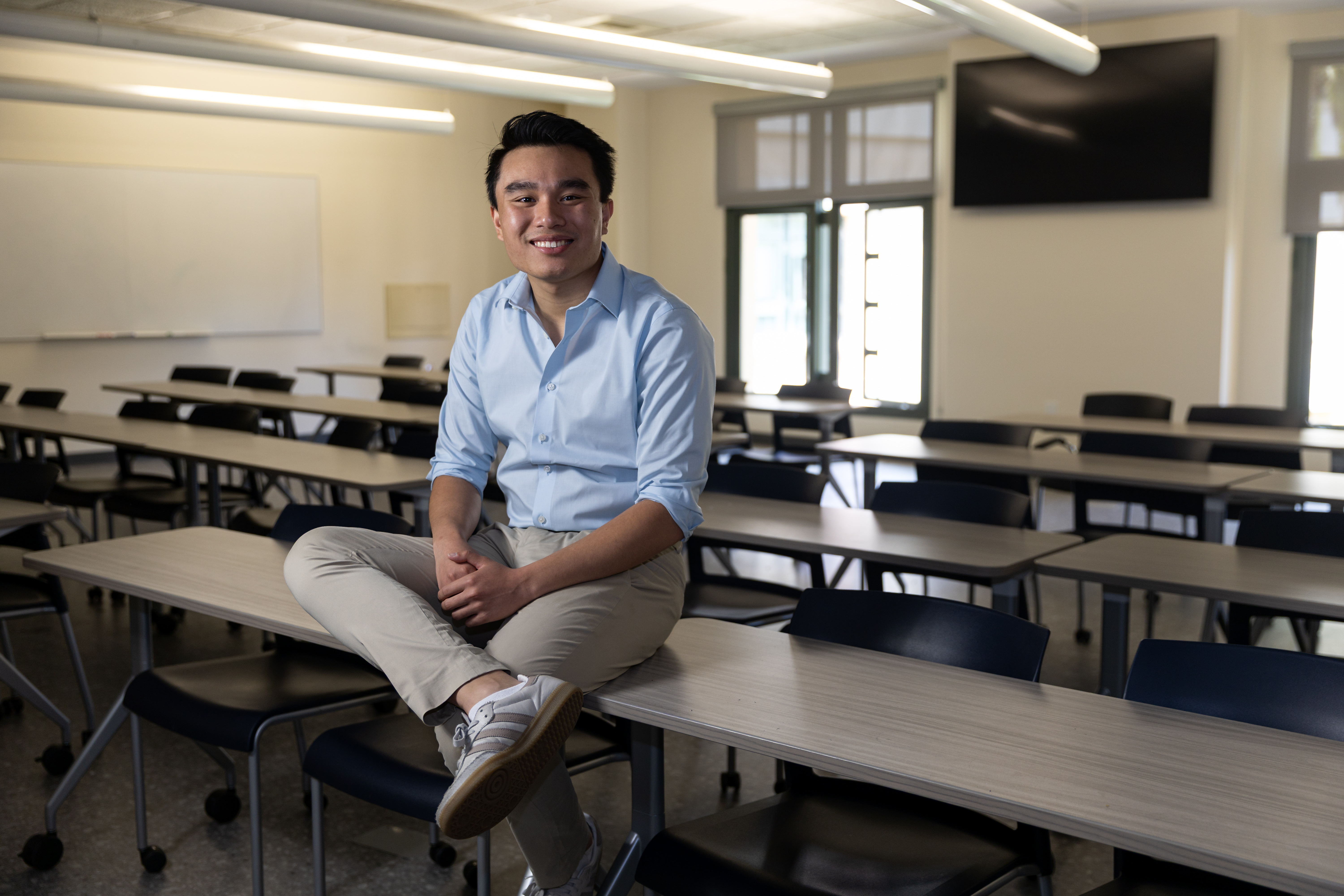 Portrait of Randy Tran in an empty classroom