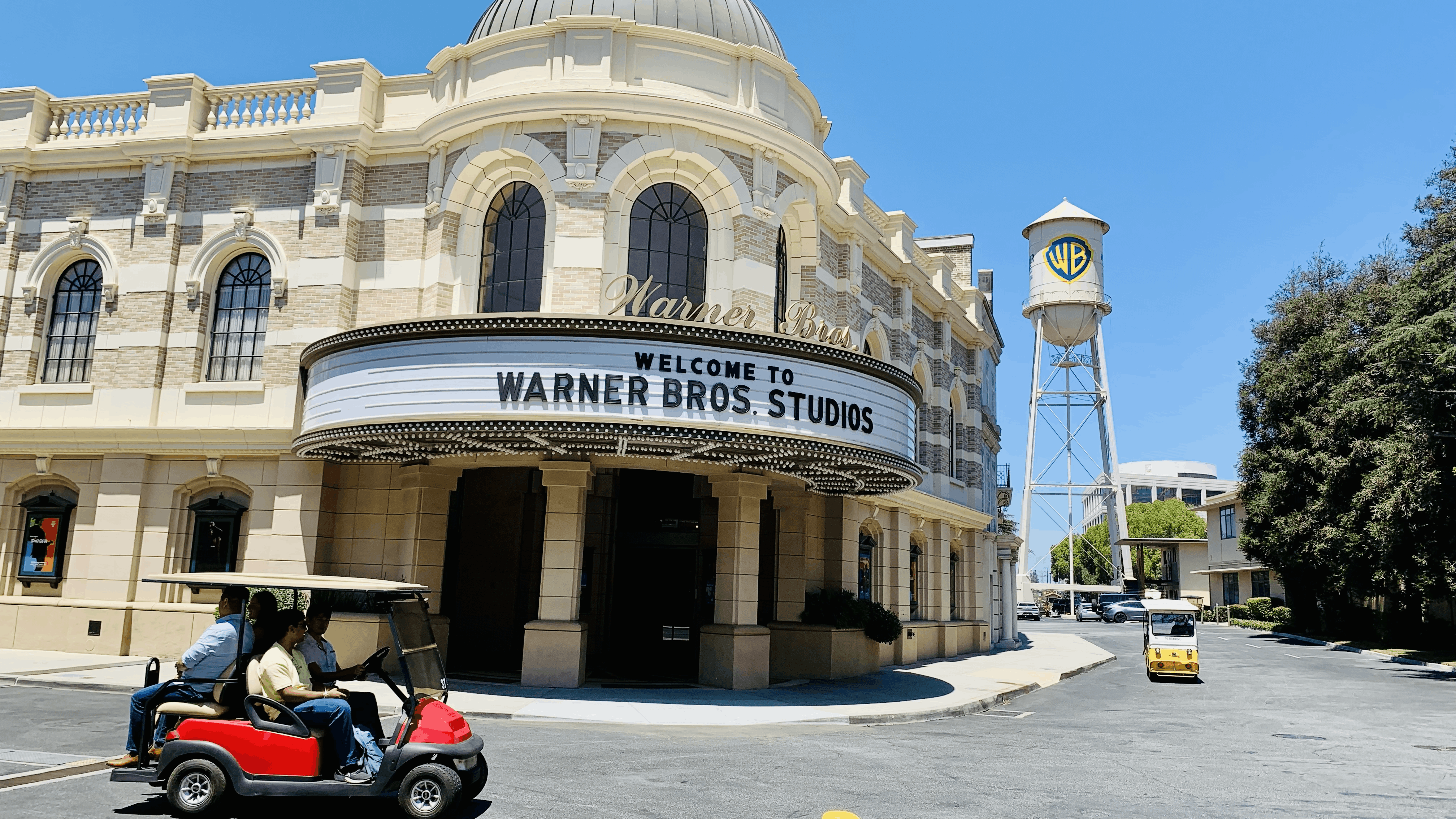 A golf cart leads students on a tour of Warner Brothers