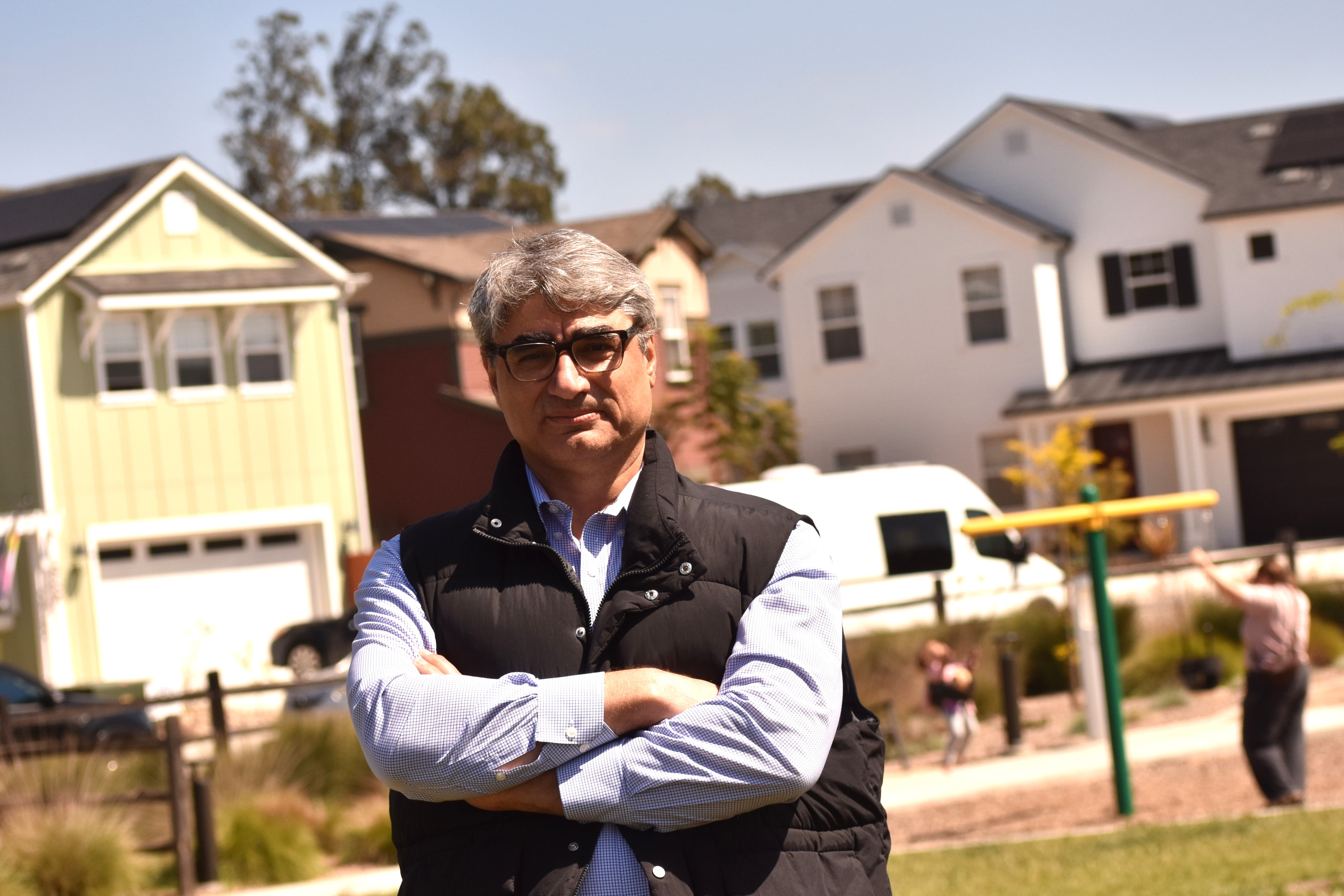 Hamed Ghoddusi poses for a portrait in a neighborhood
