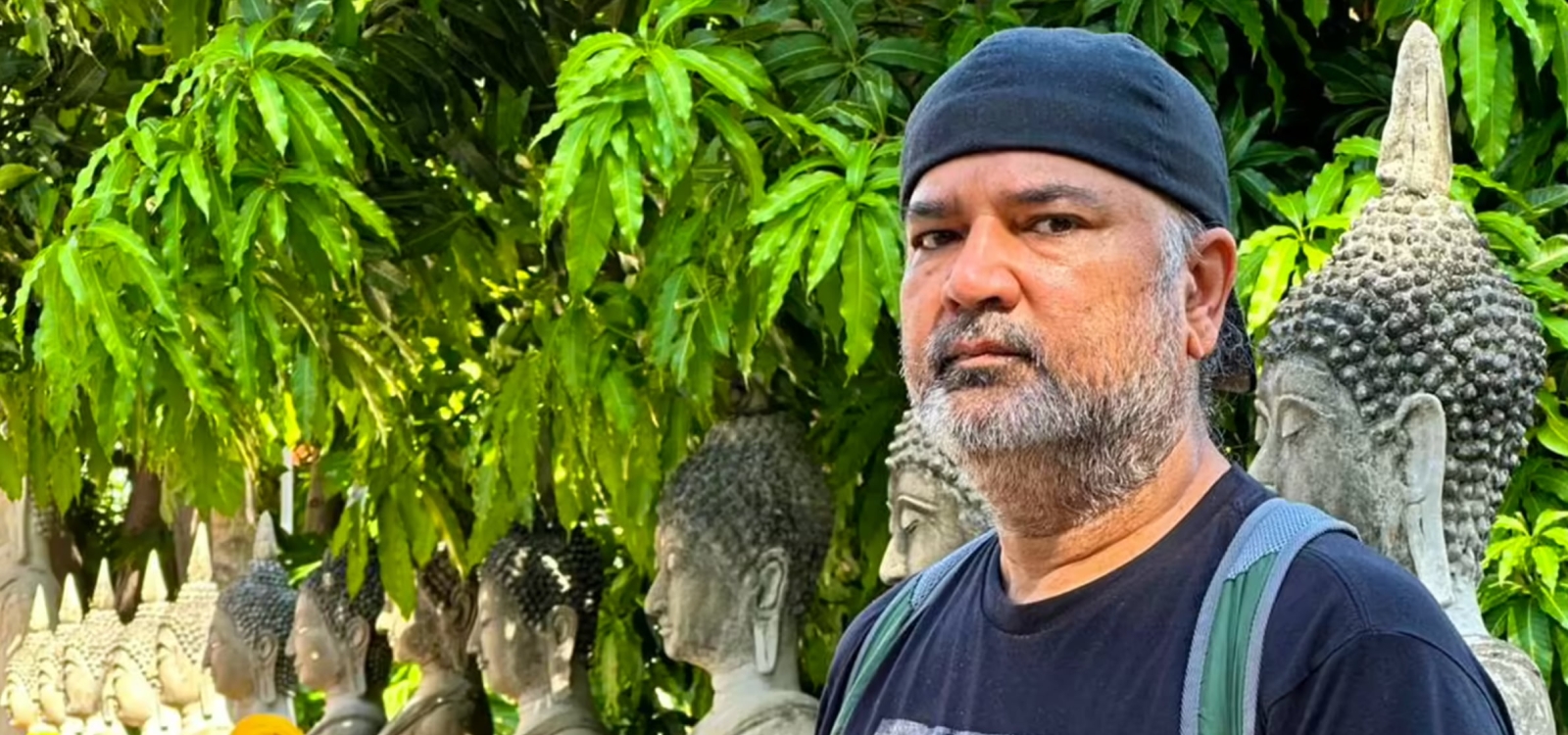 Packaging professor Jay Singh poses alongside ancient statues