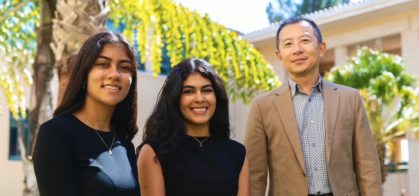 Outdoor portrait of two students with faculty mentor