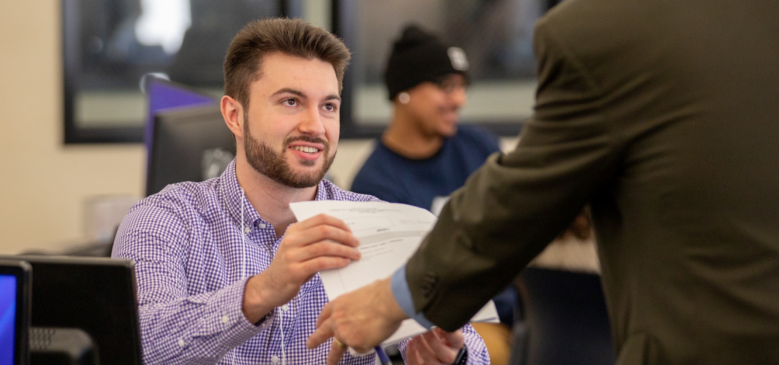A student at the Volunteer Income Tax Assistance Clinic helps a client