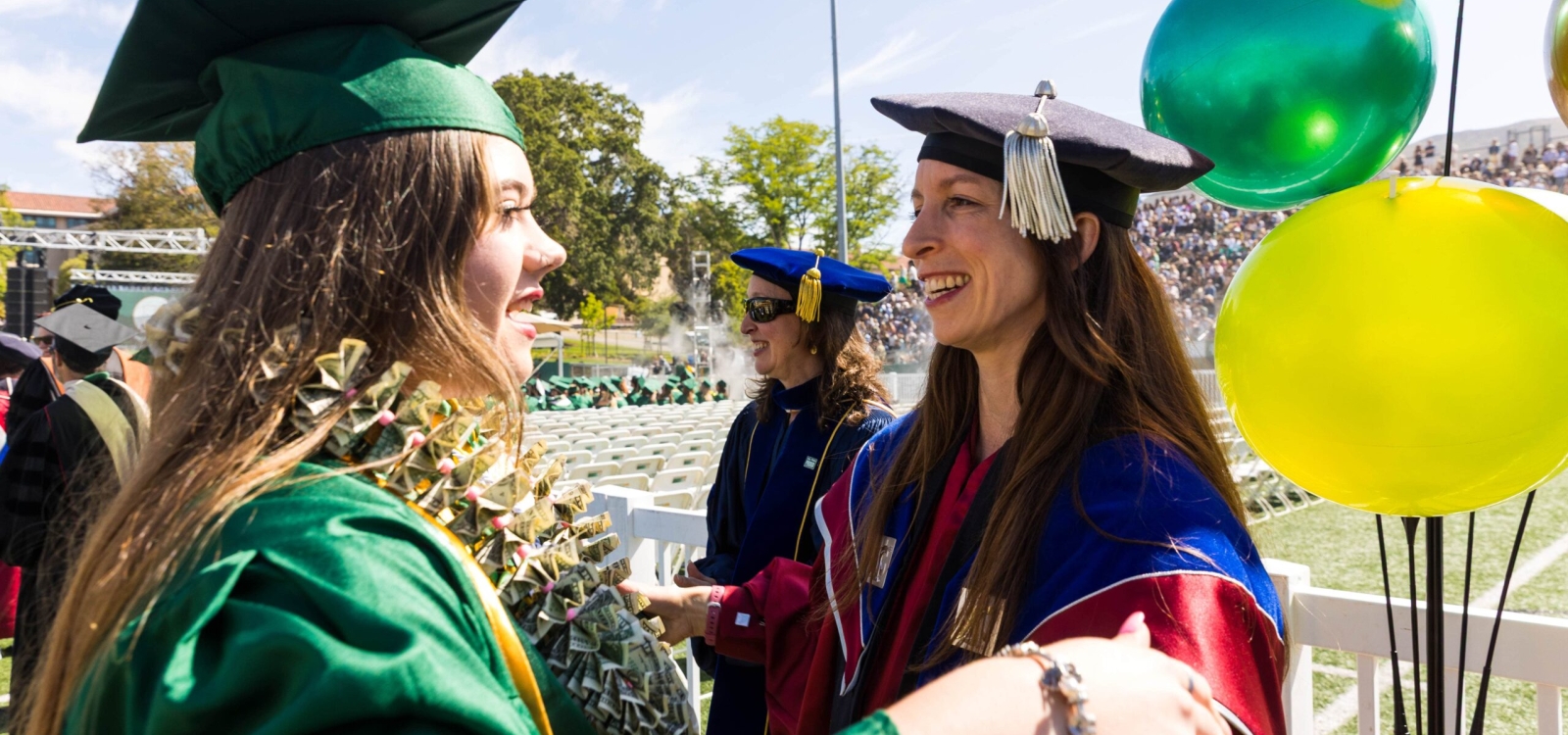 Graduate receiving her diploma from a professor on the stage