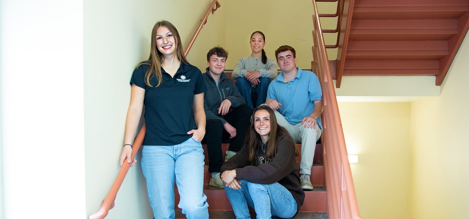 Members of the Forge Capital Group sitting on stairs in a stairwell