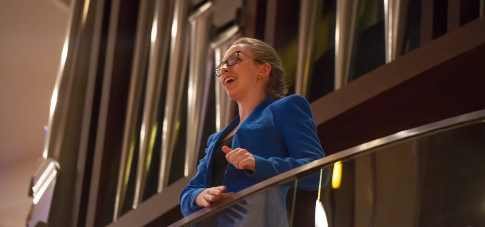 An organist speaks to students while standing in front of a pipe organ.