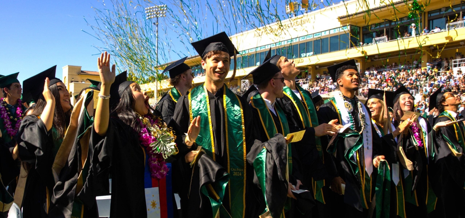 Graduates on the field looking up into the stands