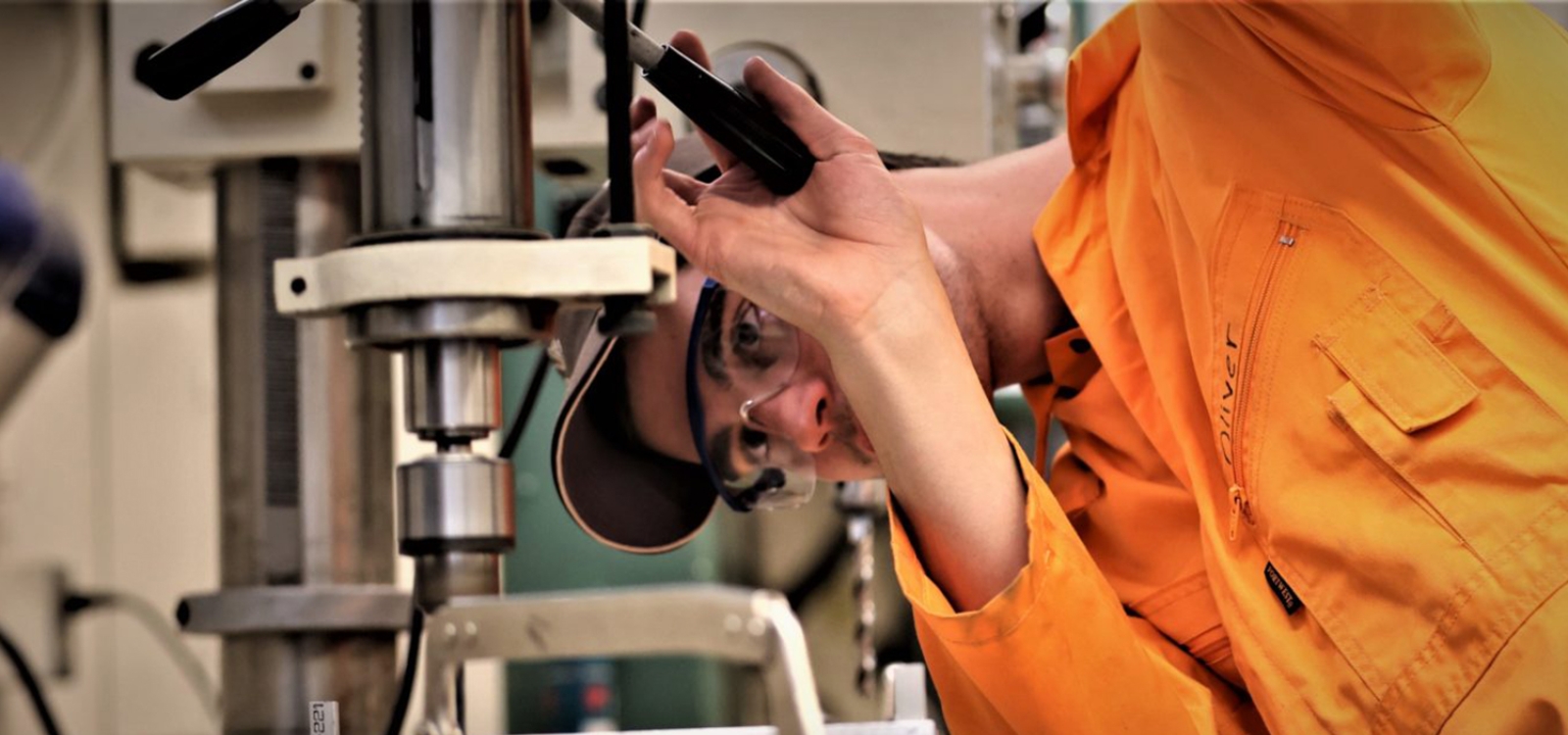 Student operating machinery to create a lighting prototype.