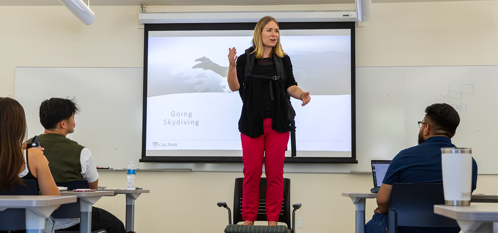 Kim Westermann stands on a chair in class to give her "skydiving" scenario