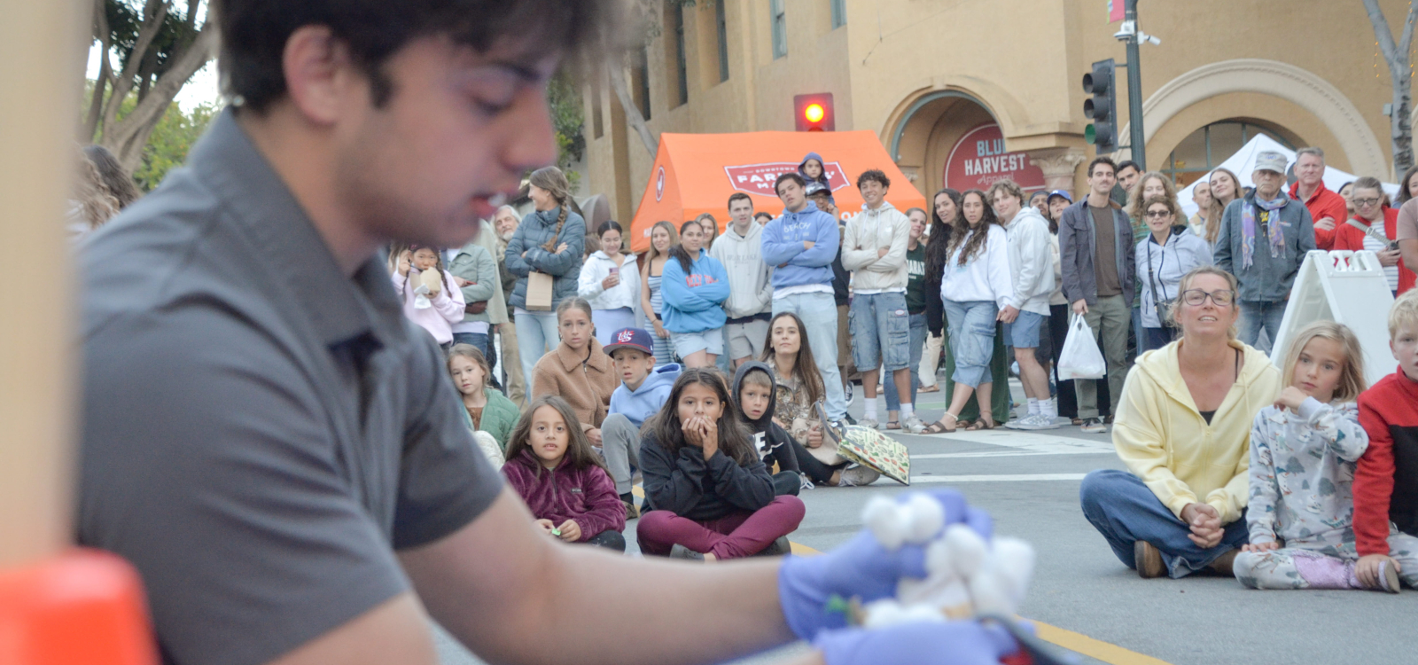 A crowd watches as a student unveils an egg