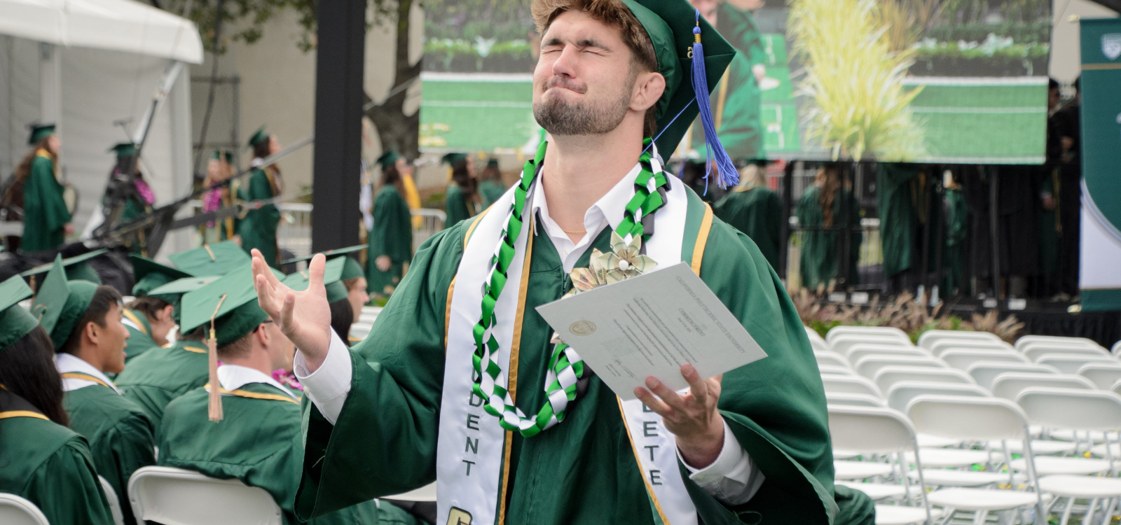A student closes his eyes in celebration after getting his degree