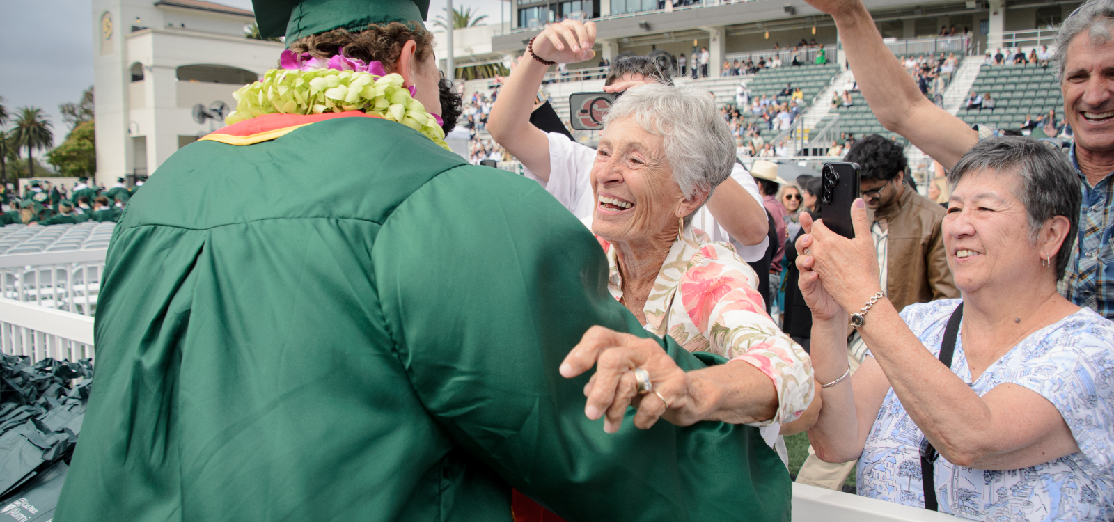 A grandmother hugs a new graduate at commencement
