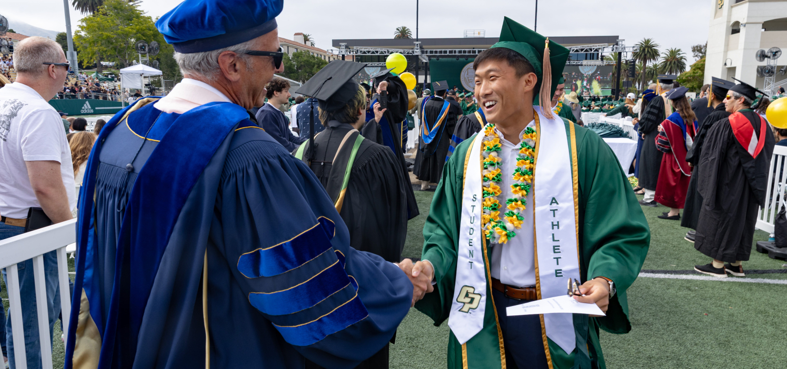 A new grad gets kudos from faculty at commencement