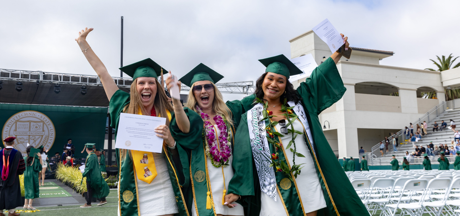 Three students celebrate getting their degrees at commencement
