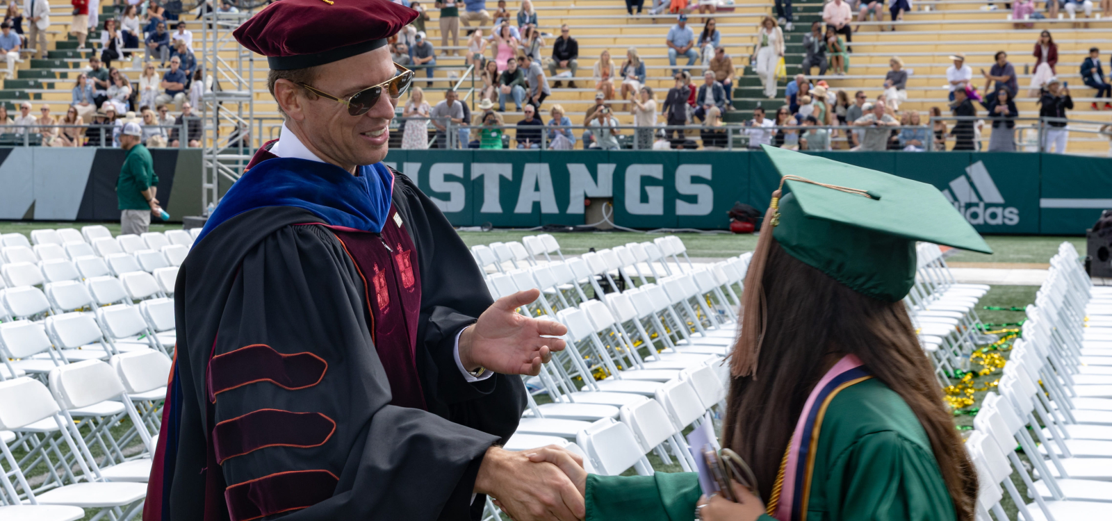 Orfalea College Dean Damon Fleming shakes the hand of a new graduate