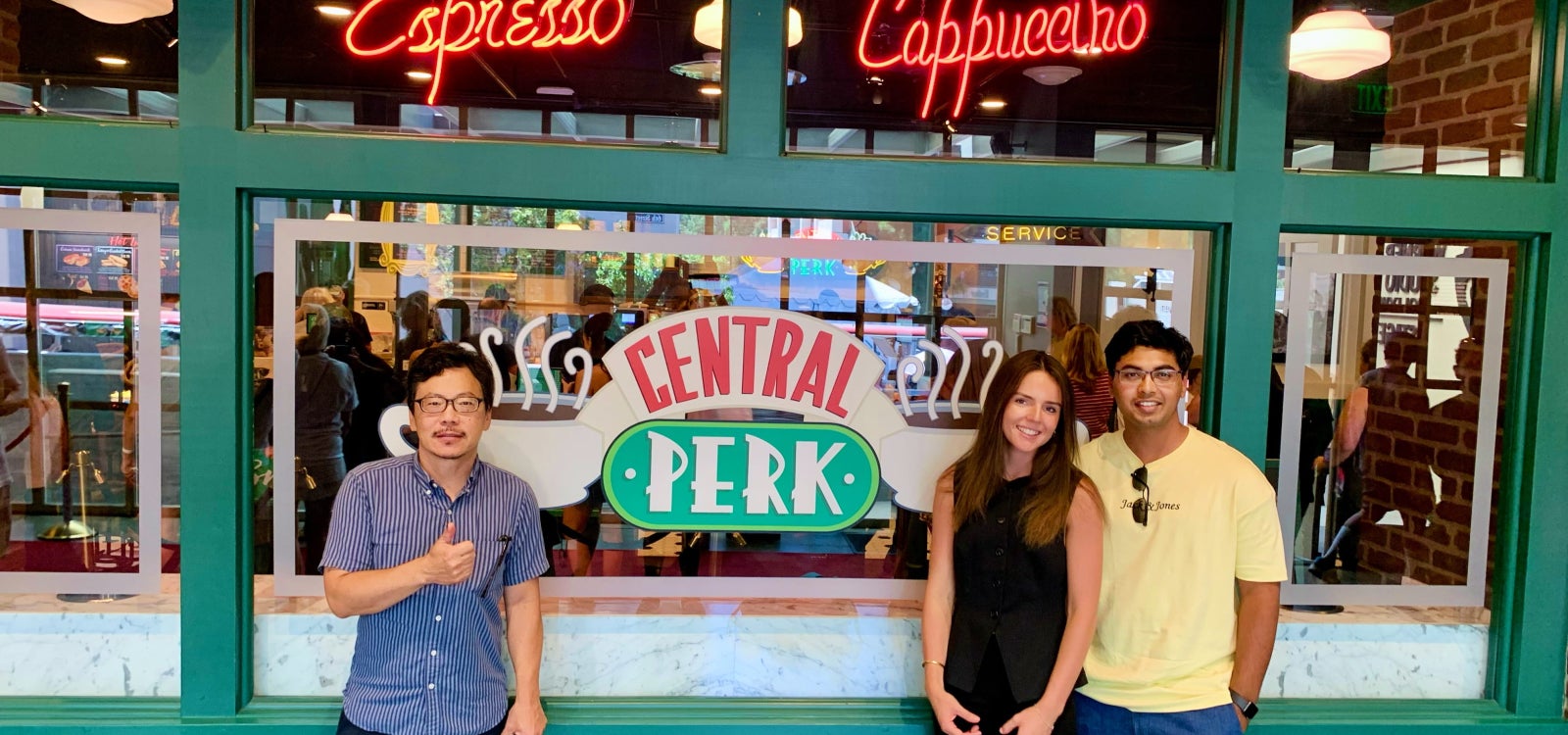 Michael Chang, Ryleigh Fitzsimmons and Ashwin Vasant pose for a photo outside the iconic Central Perk from the sitcom "Friends."