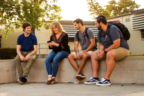 Group of students outside looking at phone