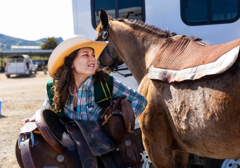 Layla Hanna puts a saddle on her horse