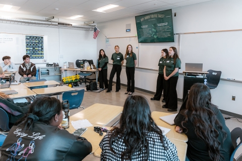 College students speak to a classroom of high school students