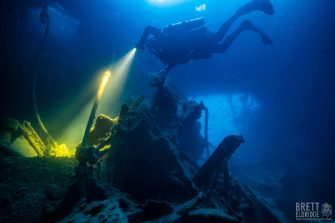 A diver, seen underwater exploring a wreck