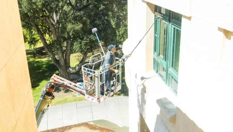 A worker uses a lift to wash windows