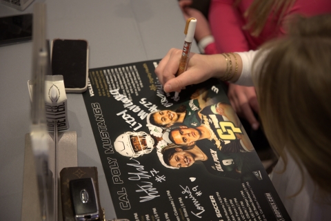 Student athlete signing a poster