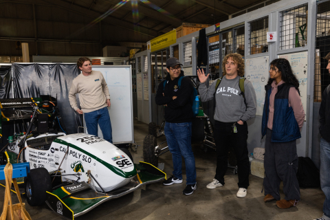 Students from the Orfalea College of Business inspect a Formula One race car designed and made by students