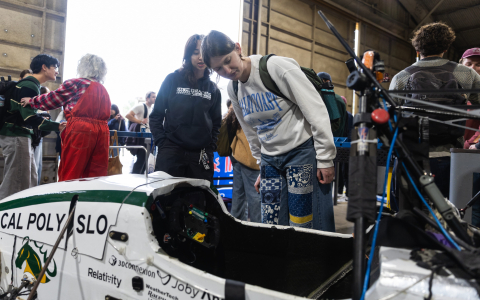Students inspect a Cal Poly Racing car at the aero hangar