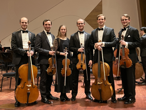 Elijah Shanks and his siblings, in symphony attire, with stringed instruments