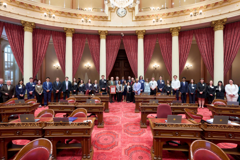 A consortium of honored Cal Poly students pose for a photo on the floor of the California Senate