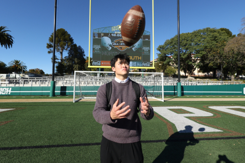 Spencer Zhang tosses a football in the air