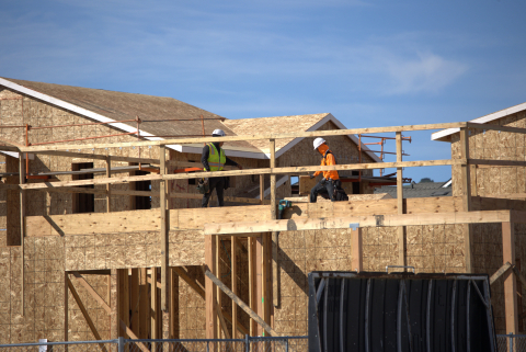 Construction workers build a house