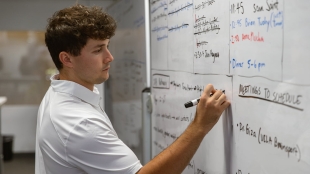 A student writes on a white board