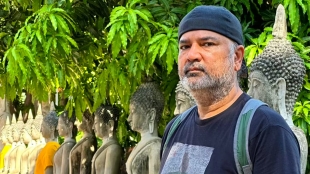 Packaging professor Jay Singh poses alongside ancient statues