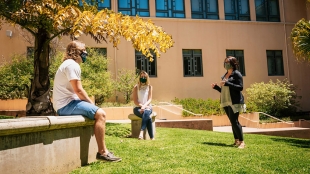 Students in masks talking outside the Orfalea building safely distancing