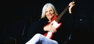 Colleen Duffy-Smith, sitting with an electric guitar in her hands