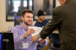A student at the Volunteer Income Tax Assistance Clinic helps a client