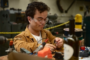 A student works with wiring in a lab