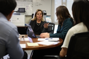 The LITC executive director speaks with members of her leadership team at a round table
