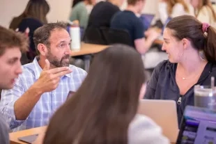 A professor speaks to students in his class