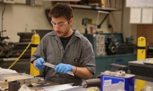 A student works on a light he's manufacturing in an industrial technology lab.